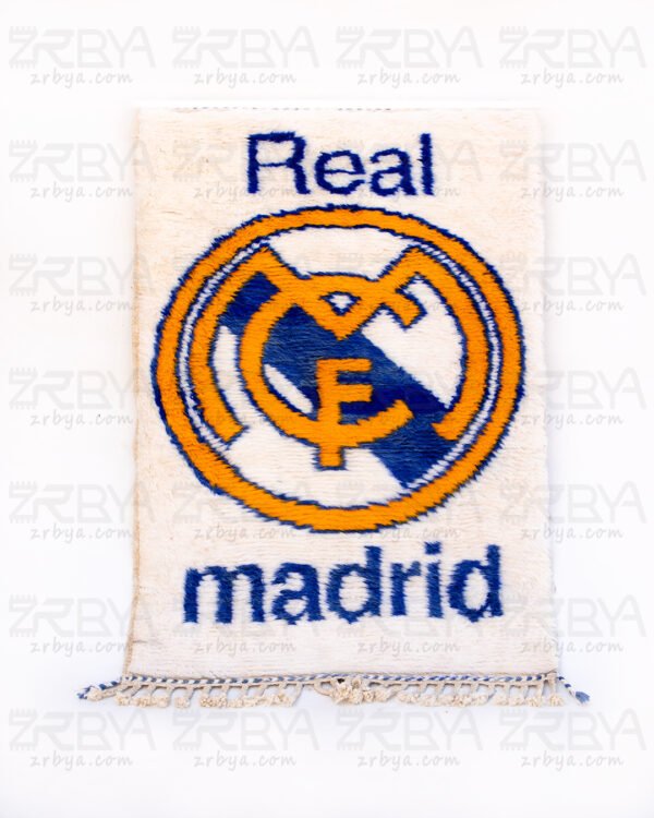 شعار ريال مدريد بالأزرق في سجادة بني وراين بيضاء ناعمة
